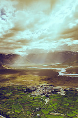 Fototapeta na wymiar aerial view of ladakh landscape, green valley field on cloudy an