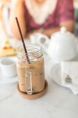 Ice coffee on table with white jar.