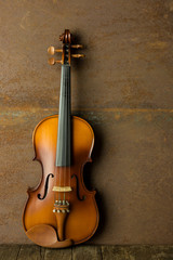Obraz na płótnie Canvas vintage violin resting against an old steel background