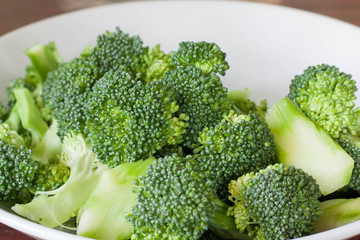 Fresh green broccoli on white dish.