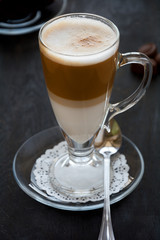 Latte Macchiato with chocolate on dark wooden table