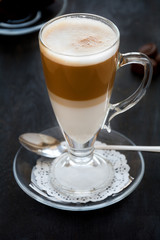 Latte Macchiato with chocolate on dark wooden table