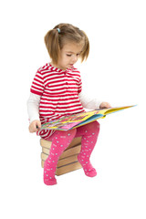 Child reading pile of books