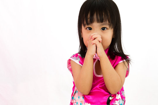 Chinese little girl wearing Cheongsam praying