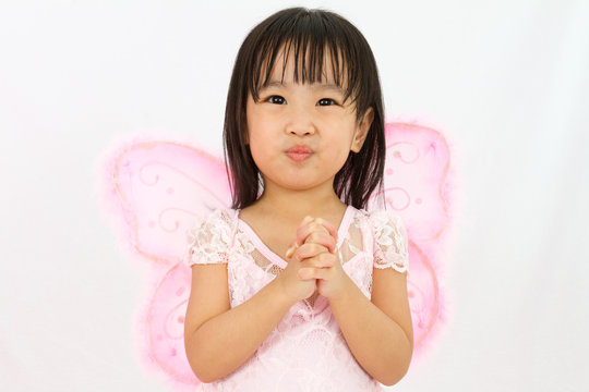 Chinese little girl wearing butterfly custome with praying gestu