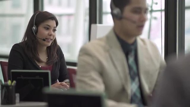 Professional in modern call center using headset and keyboard