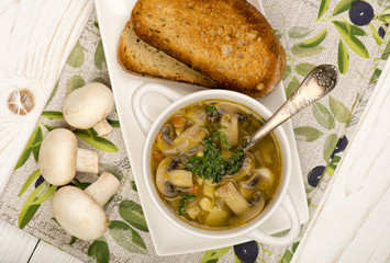 Mushroom soup with roasted bread on the wooden background.