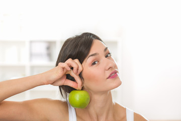 Beautiful girl holding an apple as an earring