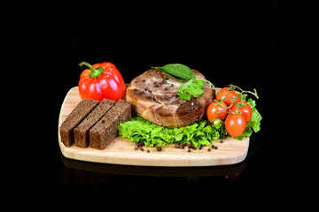 Steak with vegetables on a wooden chopping board