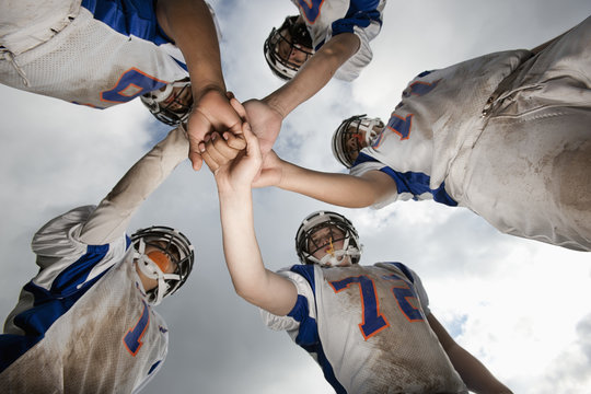 Team huddle of five football players
