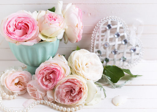 Background with  pink roses flowers  and decorative heart on whi