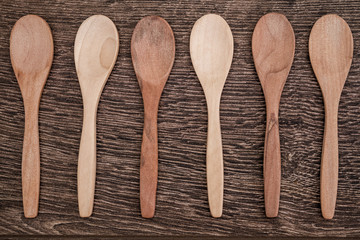 Small Size Wooden Spoons on Brown Wooden Background