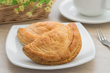 Puff pastry on plate and coffee cup