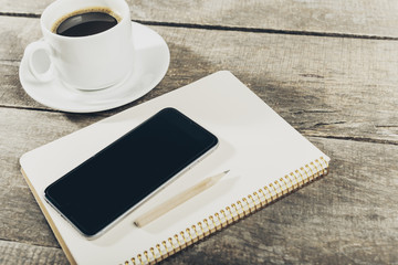Smart phone with notebook and cup of strong coffee