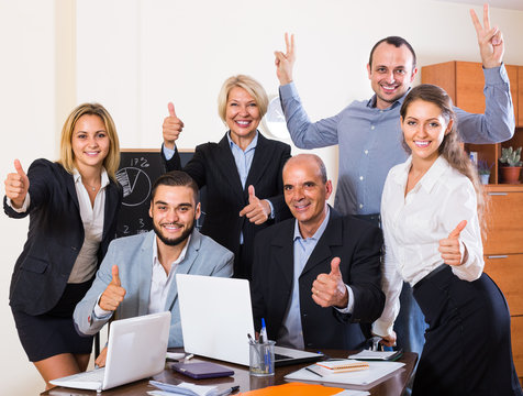 colleagues looking at laptop and smiling