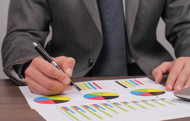 Close up of businessman working on  financial data in form of charts and diagrams. Business statistics and success concept