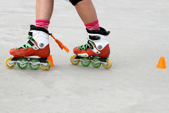 girl crossing skates while skating with cones