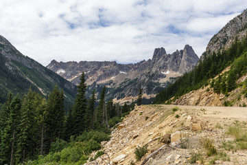 A mountain highway leading up to Washington Pass with Liberty Bell Mountain in the background.