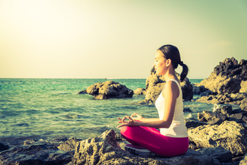 Young woman yoga action on the beach