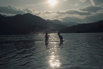 Silhoueted young couple at the beach on a hazy summer day at dus