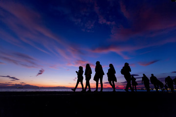 Fototapeta premium The Silhouettes are doing Activities on the Beach at Sunset