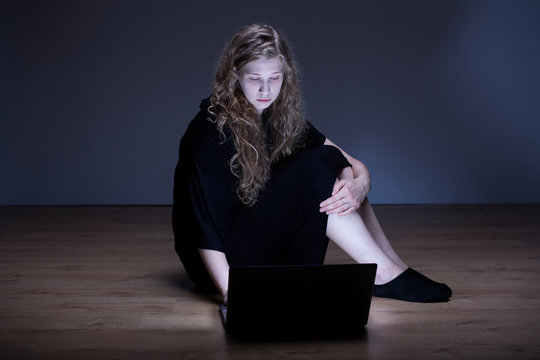 Sad girl sitting with laptop