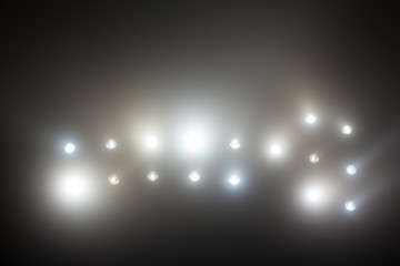 Bright white and yellow Stadium lights with fog. Defocused image