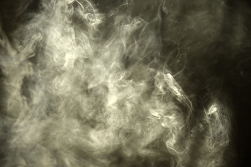 Smoke through the ray of light in a dark room
