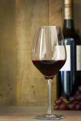 Glass and Bottle of Red Wine with Grapes