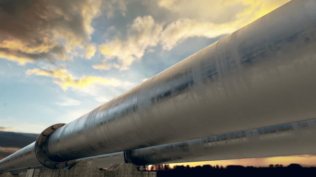 Industrial pipeline with bolted flange against sunset sky