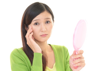 顔のシワを気にする女性