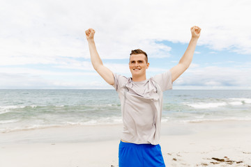Young man in sport wear with outstretched arms