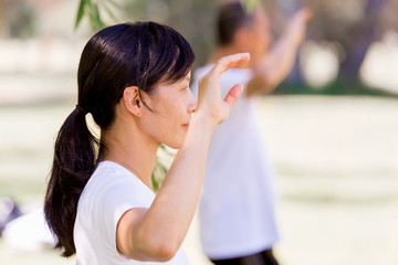 Obraz premium People practicing thai chi in park