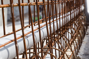 Closeup PVC pipes lined within rebar concrete divider road construction