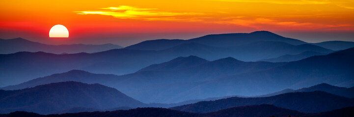 Fototapety  Zadymiony zachód słońca w górach
