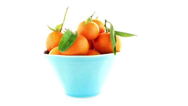Tangerines on ceramic blue bowl  isolated on white background