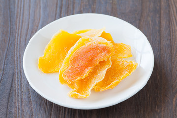 Piece of Dehydrated mango on white ceramic dish