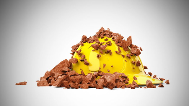 Yellow hard hat with brown debris falling and piling up