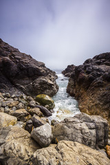 Rocky Coastline of Pacific Ocean where Waves Hit Shore