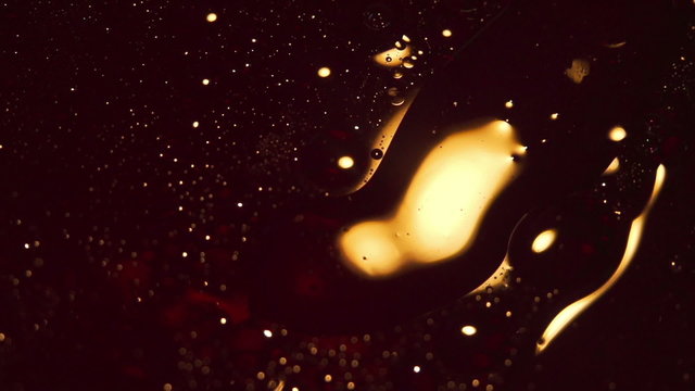 Golden Liquid Oil Swirling Around With Light Reflection Texture Background