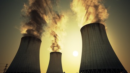 Nuclear power plant steaming cooling towers. Air pollution power station.Sunset