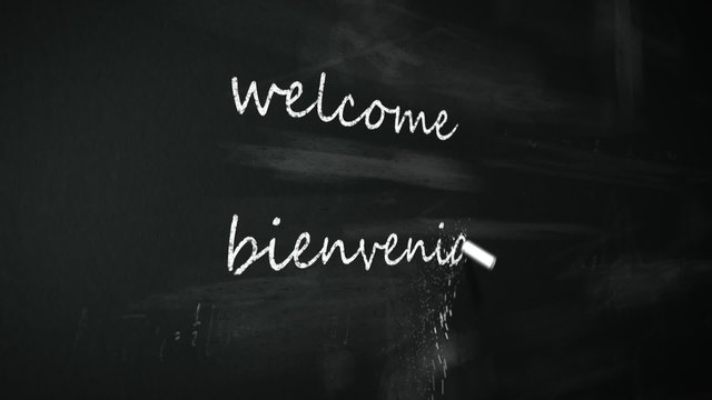 Chalk writing 'Welcome' word in multiple international foreign languages.