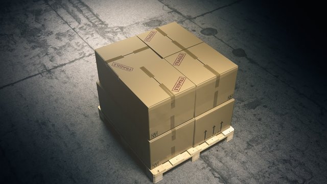 A stack of cardboard boxes on a pallet in the warehouse waiting for a forklift.
