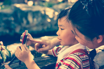Obraz premium Happy family. Woman teaching boy photographing outdoors.