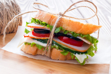 delicious sandwich with a rope tied on a cutting board