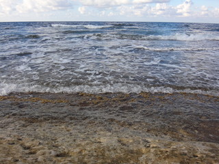 Морская волна, набегающая на берег летним вечером