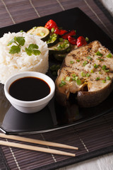 Healthy food: Steak fish, rice and soy sauce close-up. vertical
