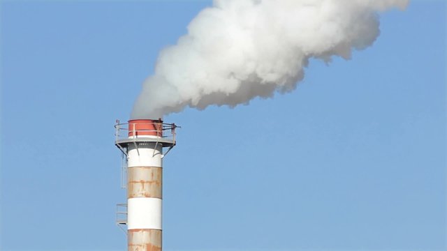 Dettaglio di una ciminiera fumante a pieno regime, inquinamento ambientale