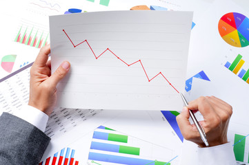 businessman observing a chart with a downward trend