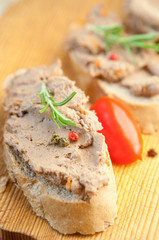 Chicken liver pate on bread with cherry tomatoes and a sprig of rosemary 